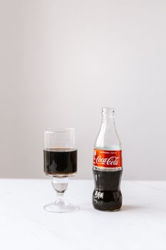 经典的可口可乐瓶子搭配极简主义背景的玻璃杯