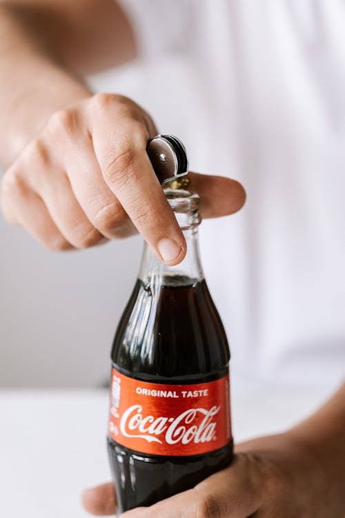 Crop anonymous man using bottle opener