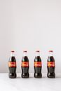 Set of same bottles full of soft drink placed on white marble table in row