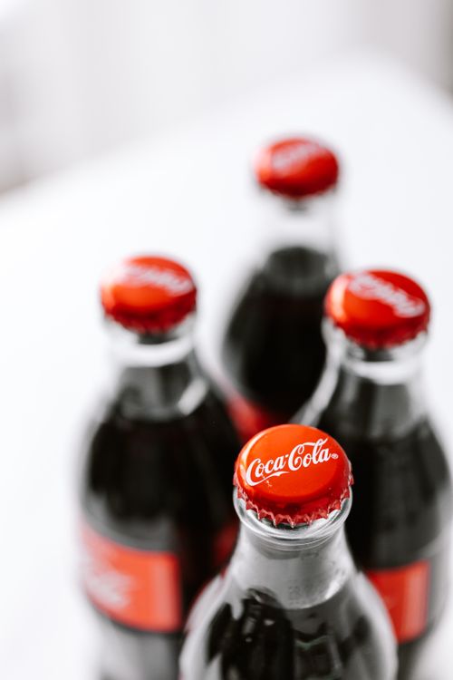 Free From above of bottles full of fresh soft drink placed on white surface Stock Photo