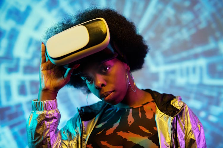 A Woman With Vr Goggles Standing By The Illuminated Background