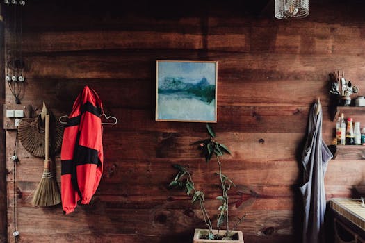 Warm wooden wall with decor items including a painting and clothing hangers.