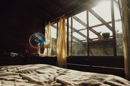 White Bed Linen Near Brown Wooden Window Frame