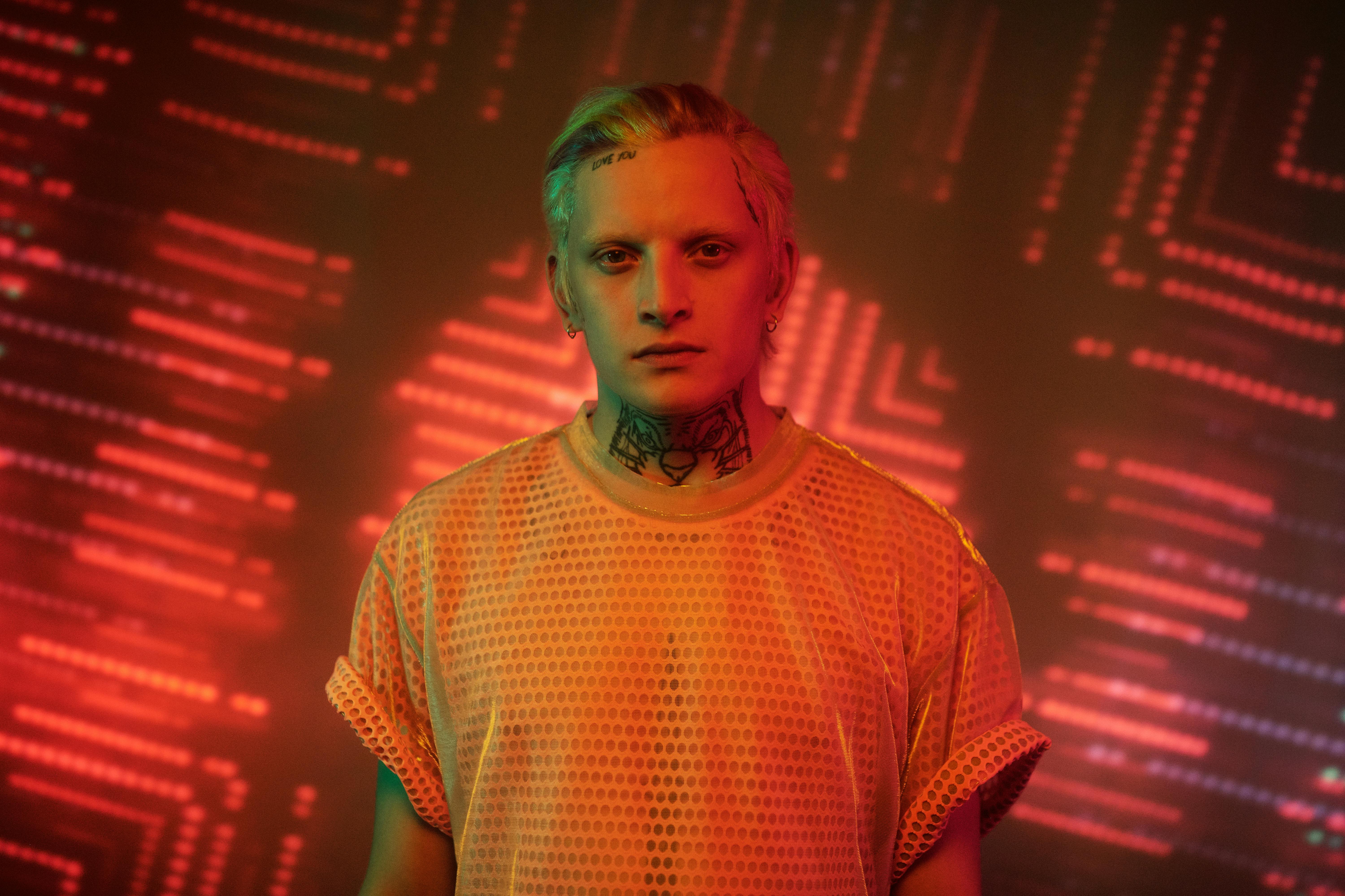 A striking portrait of a person with tattoos, illuminated by dynamic neon lights.