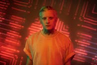 一幅由动态霓虹灯照亮的纹身人物肖像，引人注目