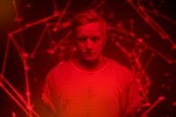 在红色灯光下，男子的动态肖像被几何图案环绕，唤起了未来派的情绪