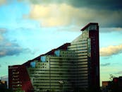 一座现代建筑拥有独特的倾斜立面，在阴天拍摄而成