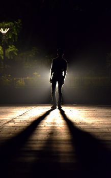 路灯下，一个孤独的剪影在夜晚投下长长的影子
