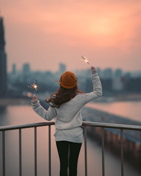 冬日黄昏，一名年轻女子在俯瞰首尔的阳台上燃放烟火庆祝