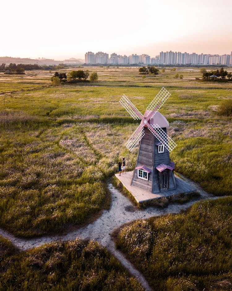 Windmill On Green Grass Field