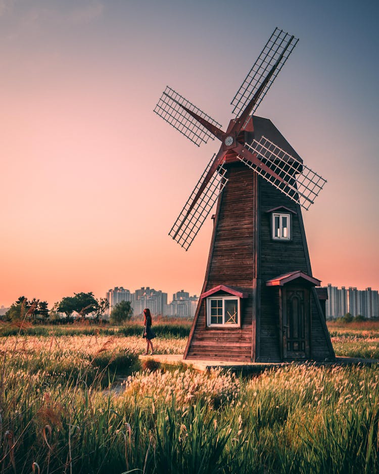 Brown Wooden Windmill On Green Grass Field