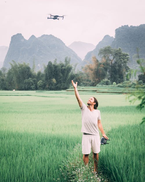 Woman in Gray Shirt Standing on Green Grass Field