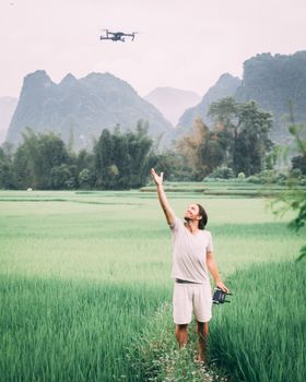 Man flying drone over vibrant rice fields in Vietnam's scenic landscape.