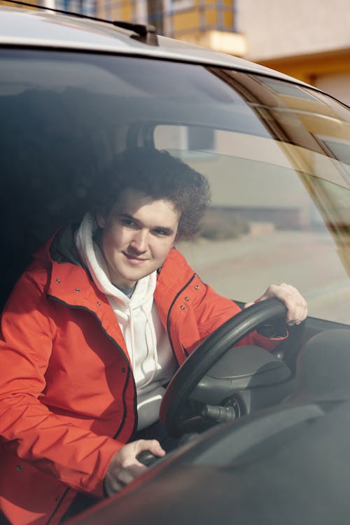 Woman in Red Jacket Driving Car