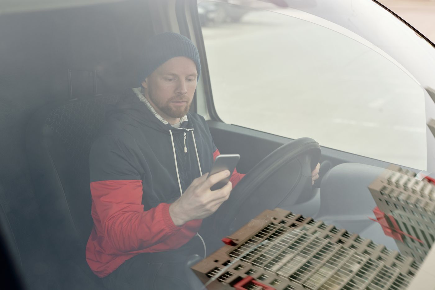 Service worker checking his phone from a parked vehicle