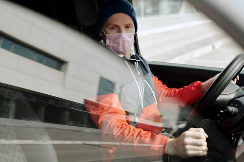 Free Man Wearing a Face Mask Driving a Vehicle Stock Photo