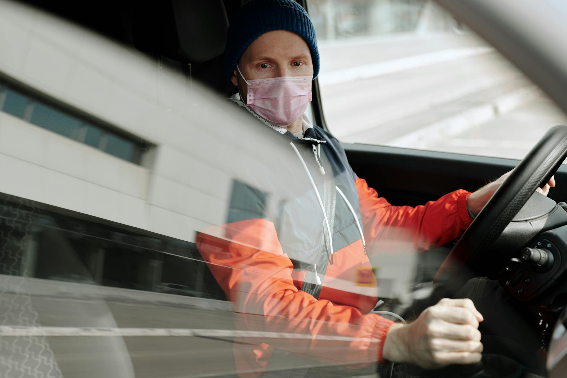 Man Wearing a Face Mask Driving a Vehicle