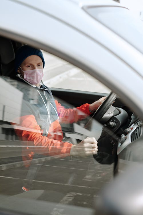 Man Wearing a Face Mask Driving a Vehicle