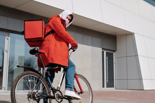 A cyclist wearing a mask delivering food in an urban environment, representing safe delivery practices.