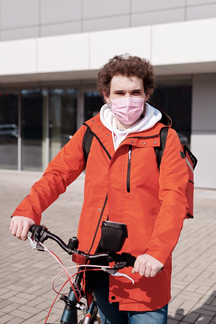 Delivery Man Wearing A Face Mask And Riding A Bicycle