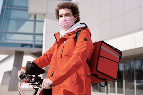 Delivery Man Wearing a Face Mask and Riding a Bicycle