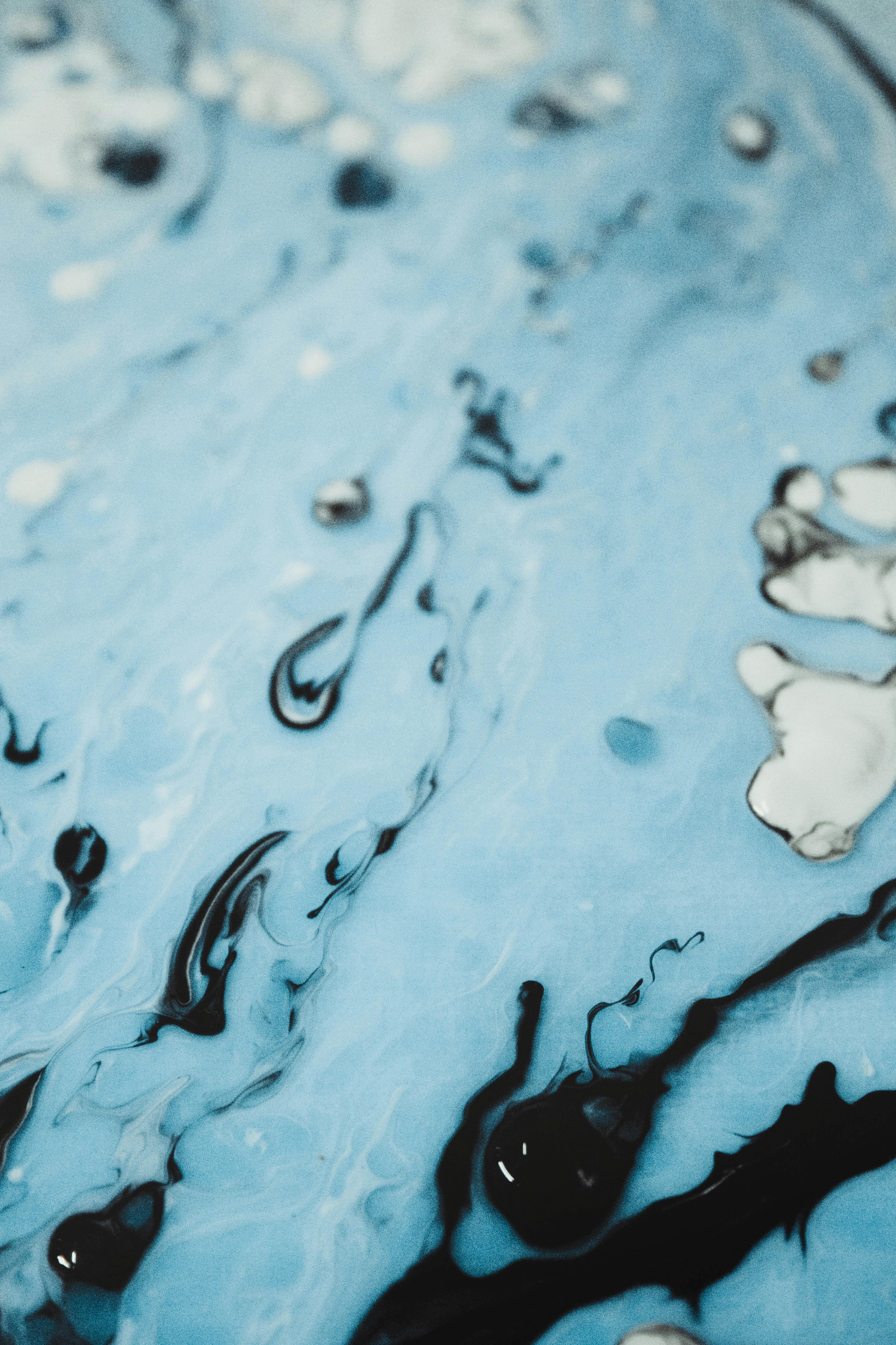 Abstract light blue liquid form with black drops Free Stock Photo