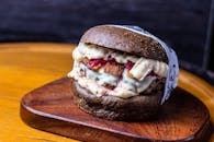 Delectable hamburger with cheese sauce served on wooden board