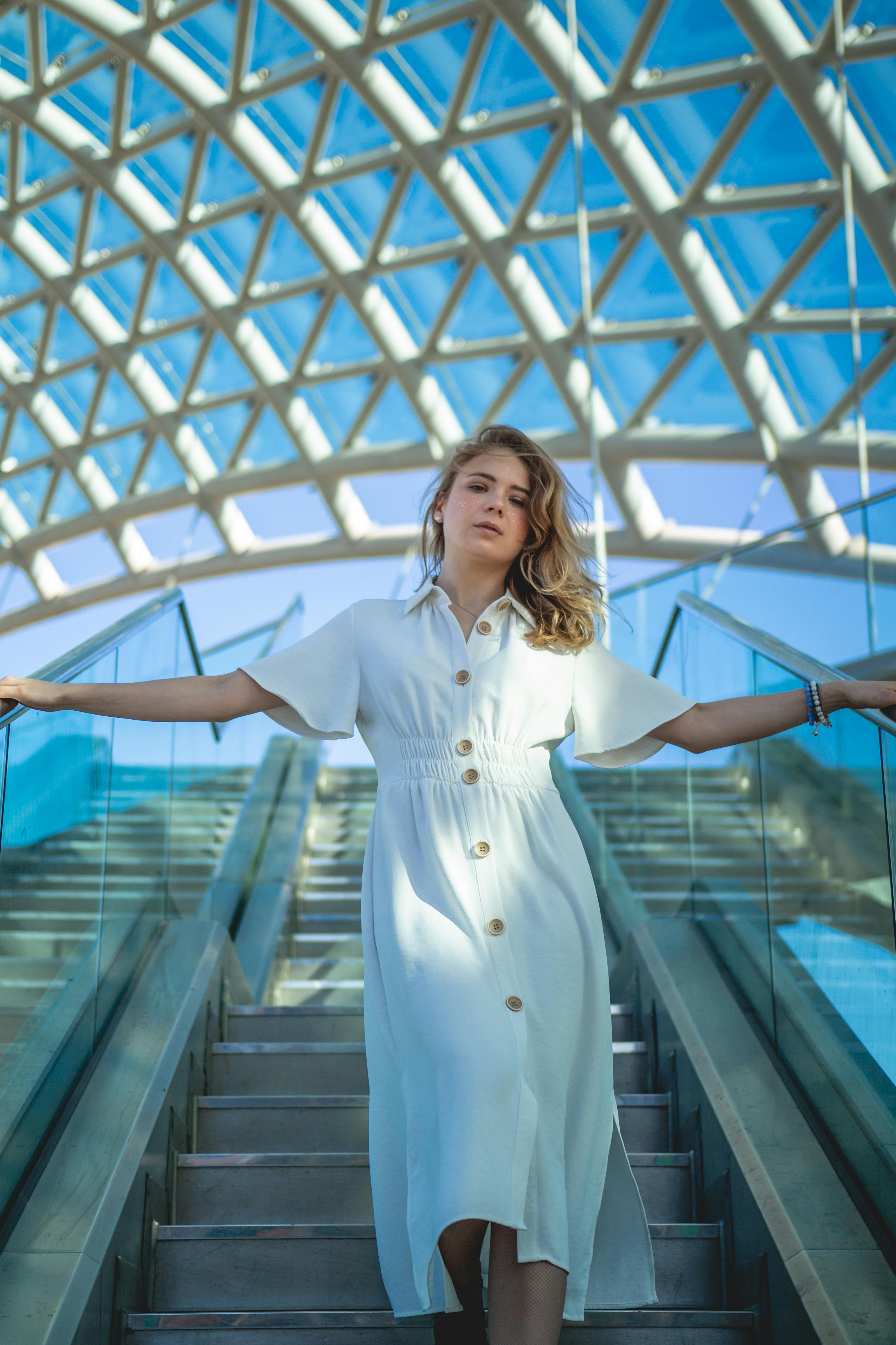 woman in white long sleeve dress standing on stairs