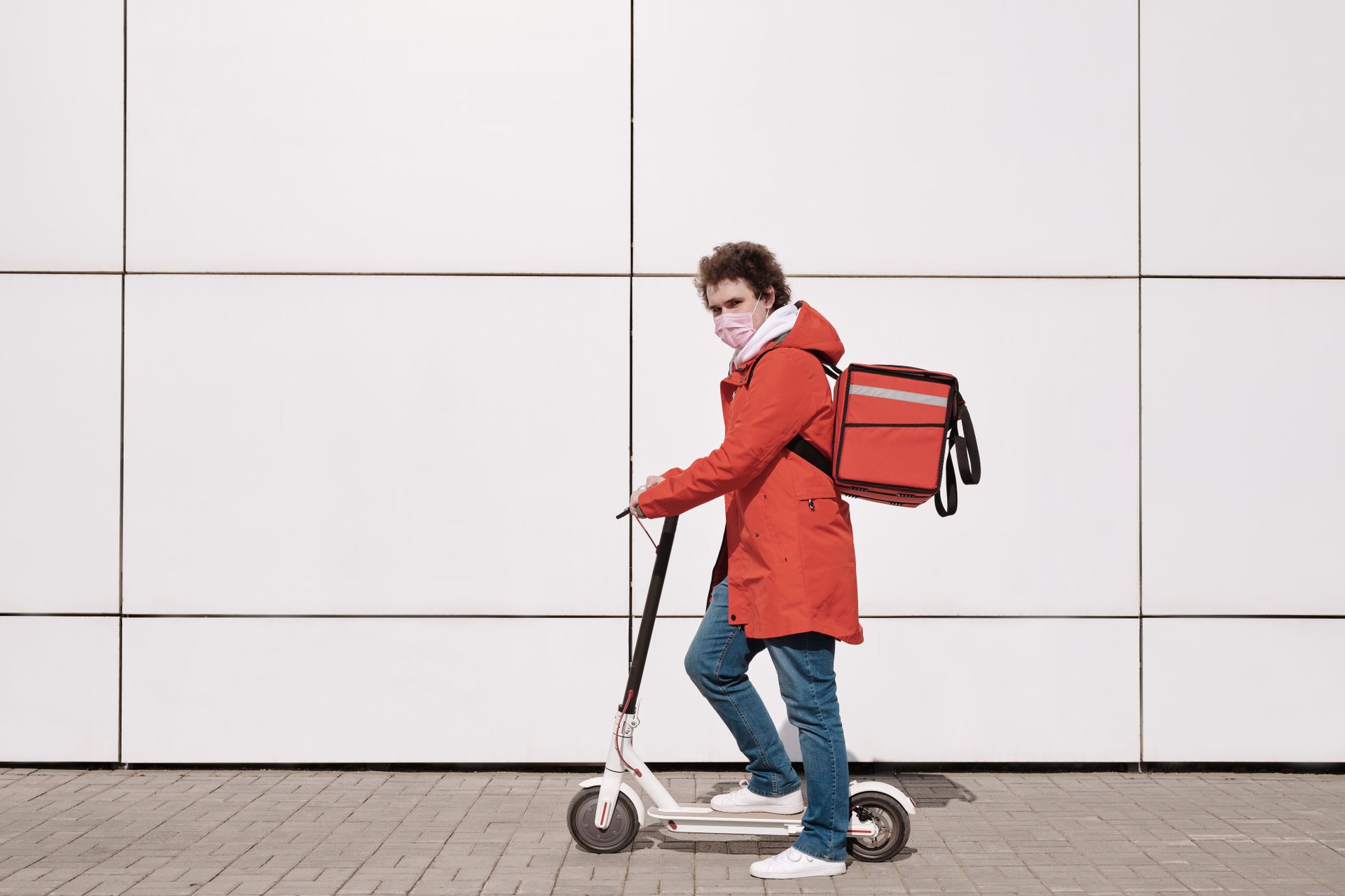 Delivery Man Wearing a Face Mask and Riding a Scooter