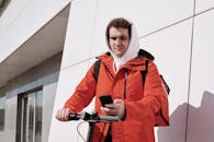 Pizza Deliveryman on a e-Scooter Reading a Text Message