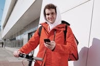 Man Holding Cellphone and a Scooter