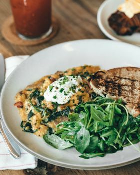 Savor the freshness of a spinach omelette meal with greens and toast, perfect for a satisfying brunch.