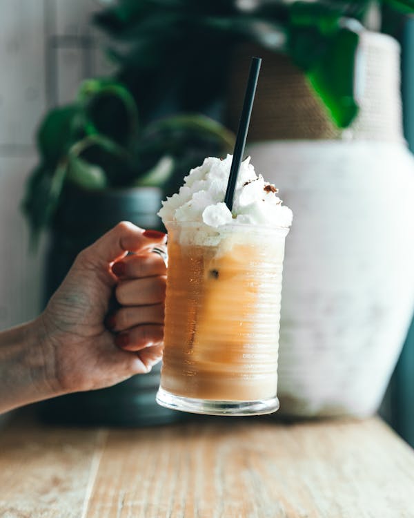 Free Person Holding Clear Drinking Glass With White Cream Stock Photo