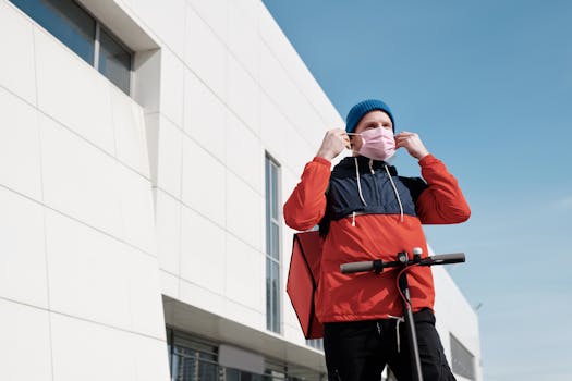 Delivery person with face mask and scooter, illustrating pandemic safety during outdoor deliveries.