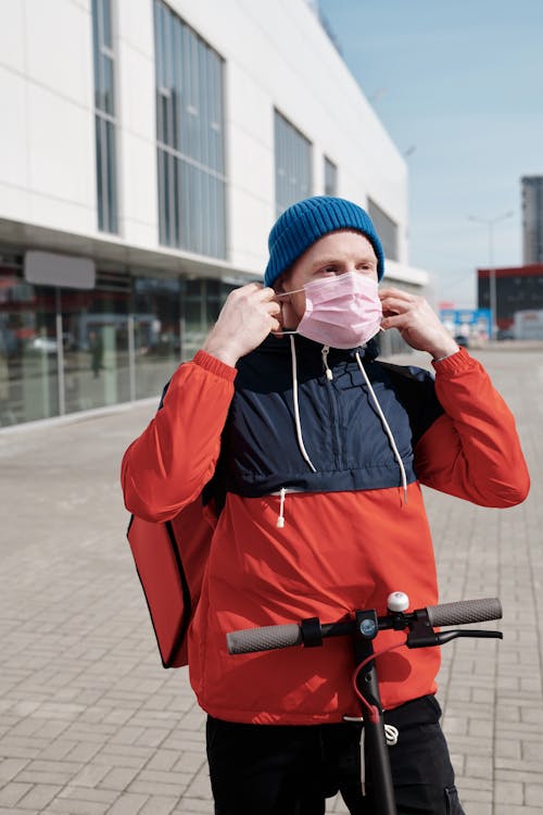 Free Delivery Man Putting on a Face Mask Stock Photo
