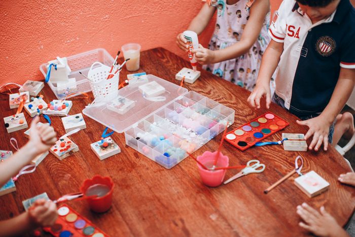 Overhead view of children painting with watercolours in a workshop