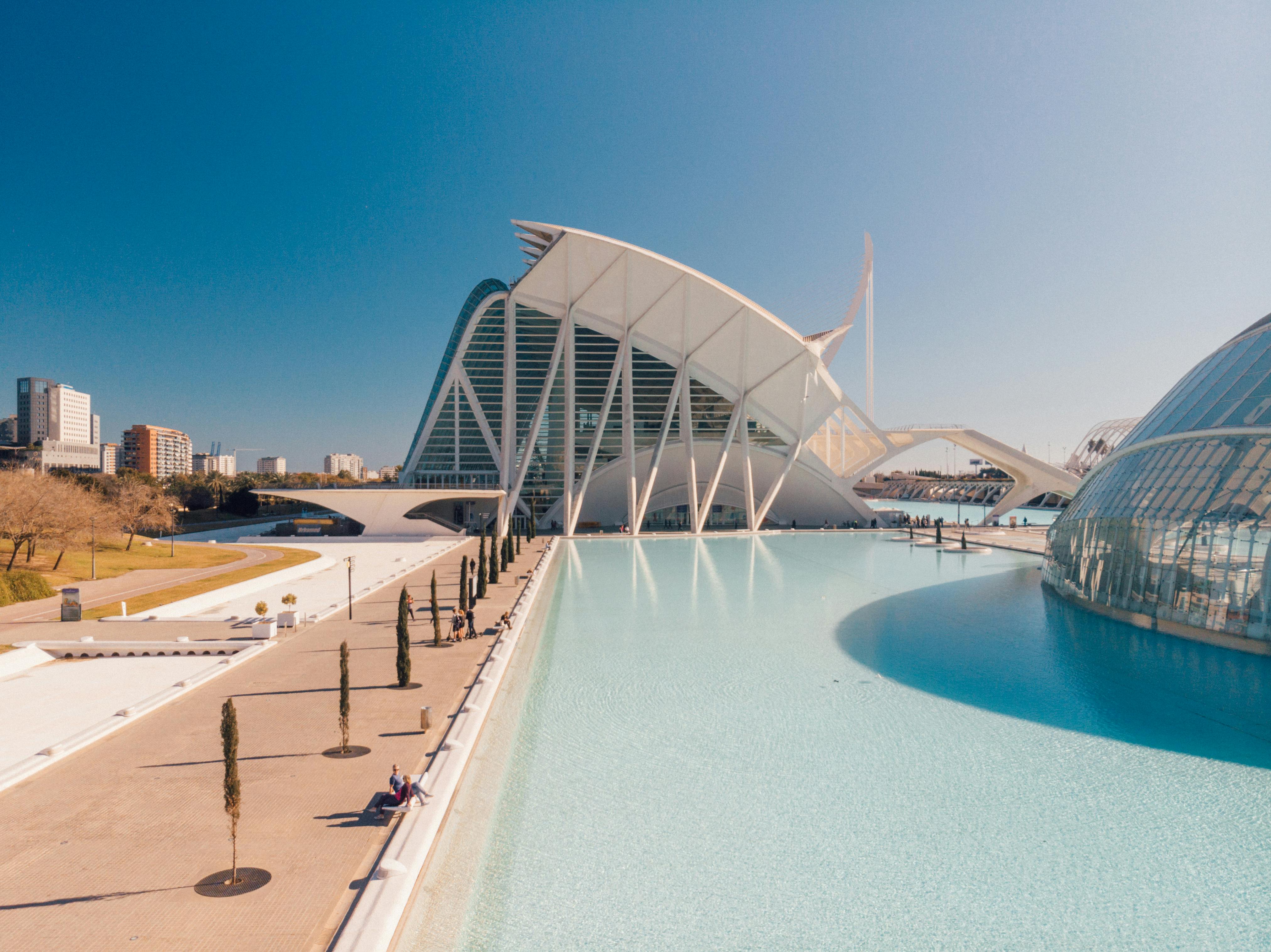 Stunning modern architecture at City of Arts and Sciences, Valencia, Spain, sunlit and reflected in a serene pond.