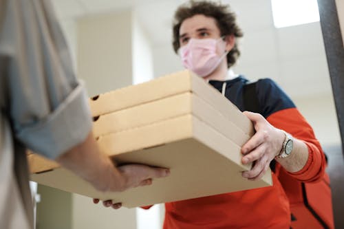 Man Wearing a Face Mask Delivering Pizza