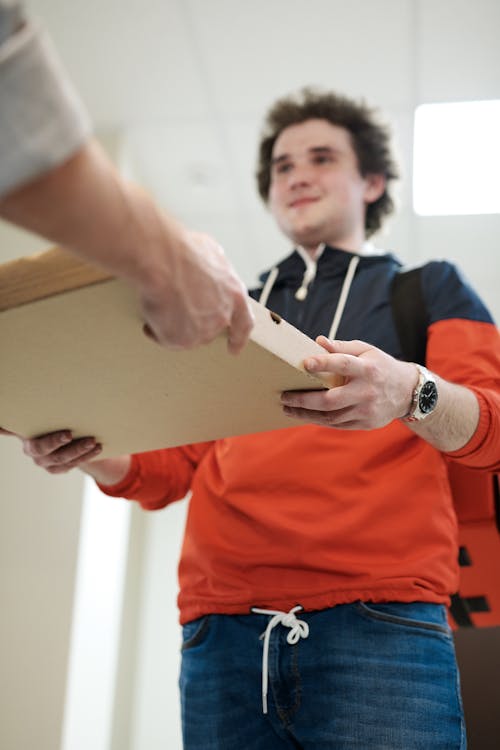 Low-Angle Shot of a Man Delivering a Pizza