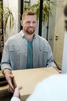 Man with short hair and beard delivering a package in an indoor setting.