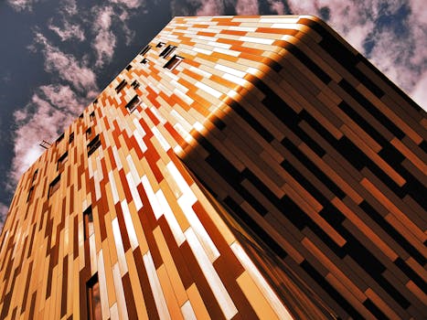 低角度镜头捕捉了现代化、色彩缤纷的建筑立面与戏剧性天空的映衬