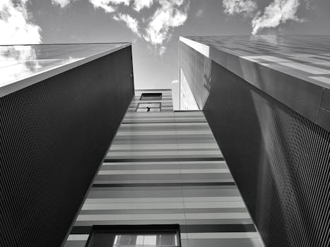 低角度拍摄的黑白照片捕捉了现代摩天大楼，云层引人注目