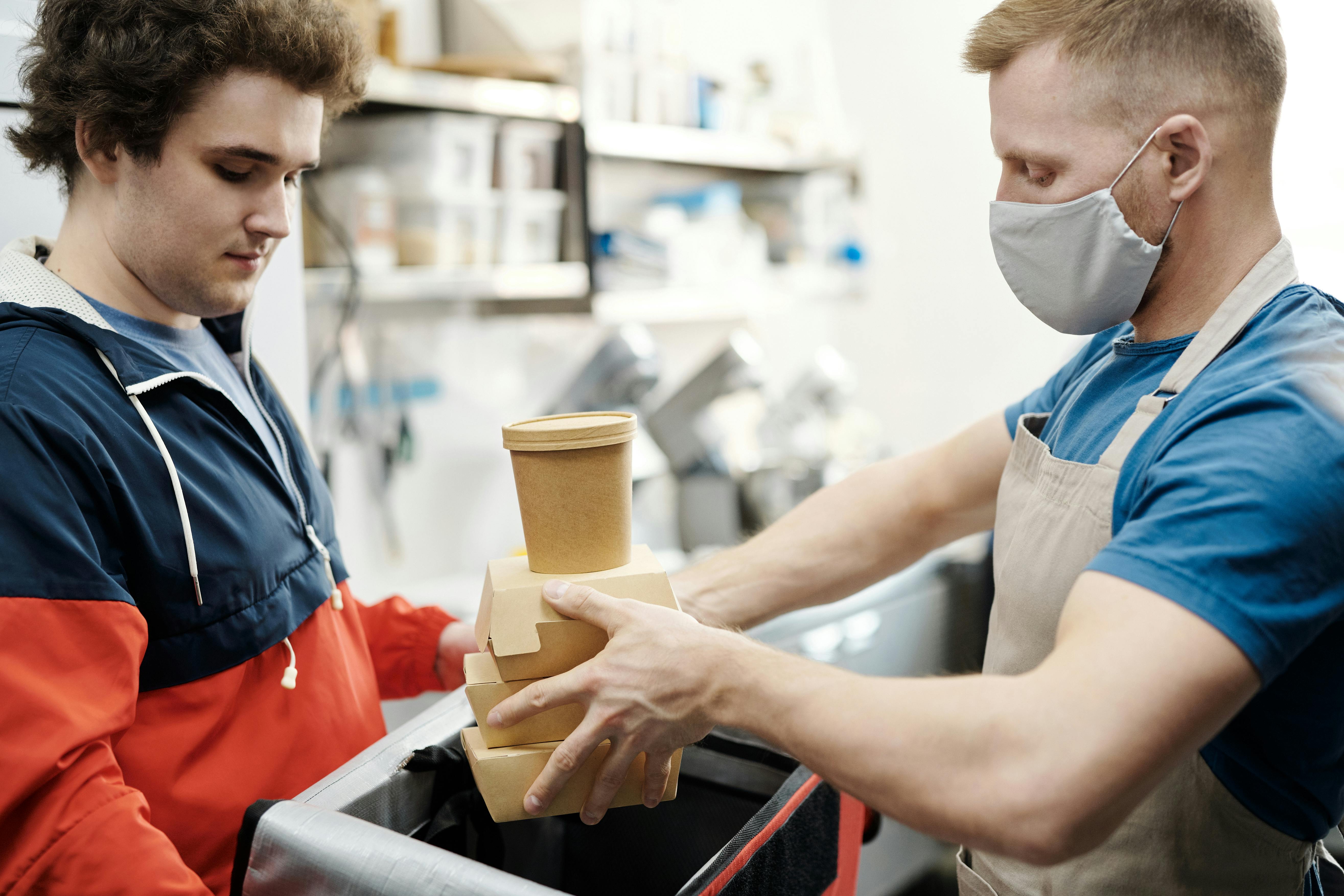 men putting food on a thermal bag