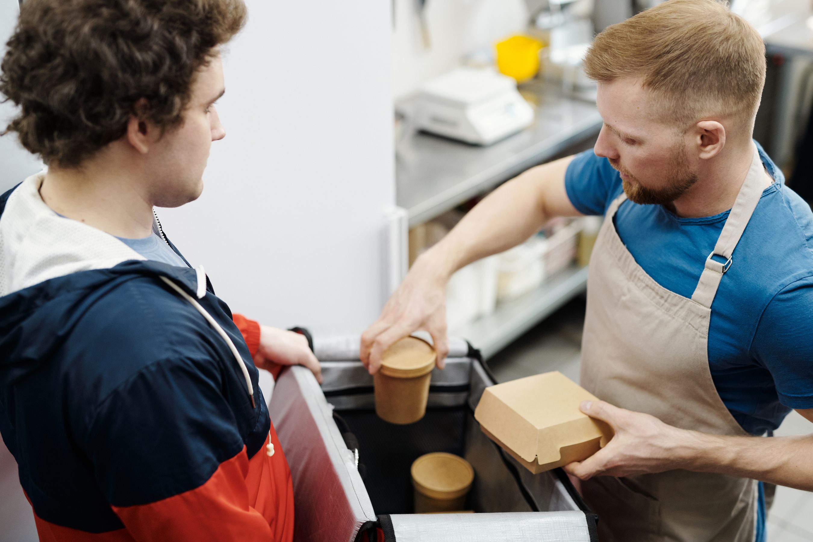 Restaurant worker packing takeaway containers into a delivery bag