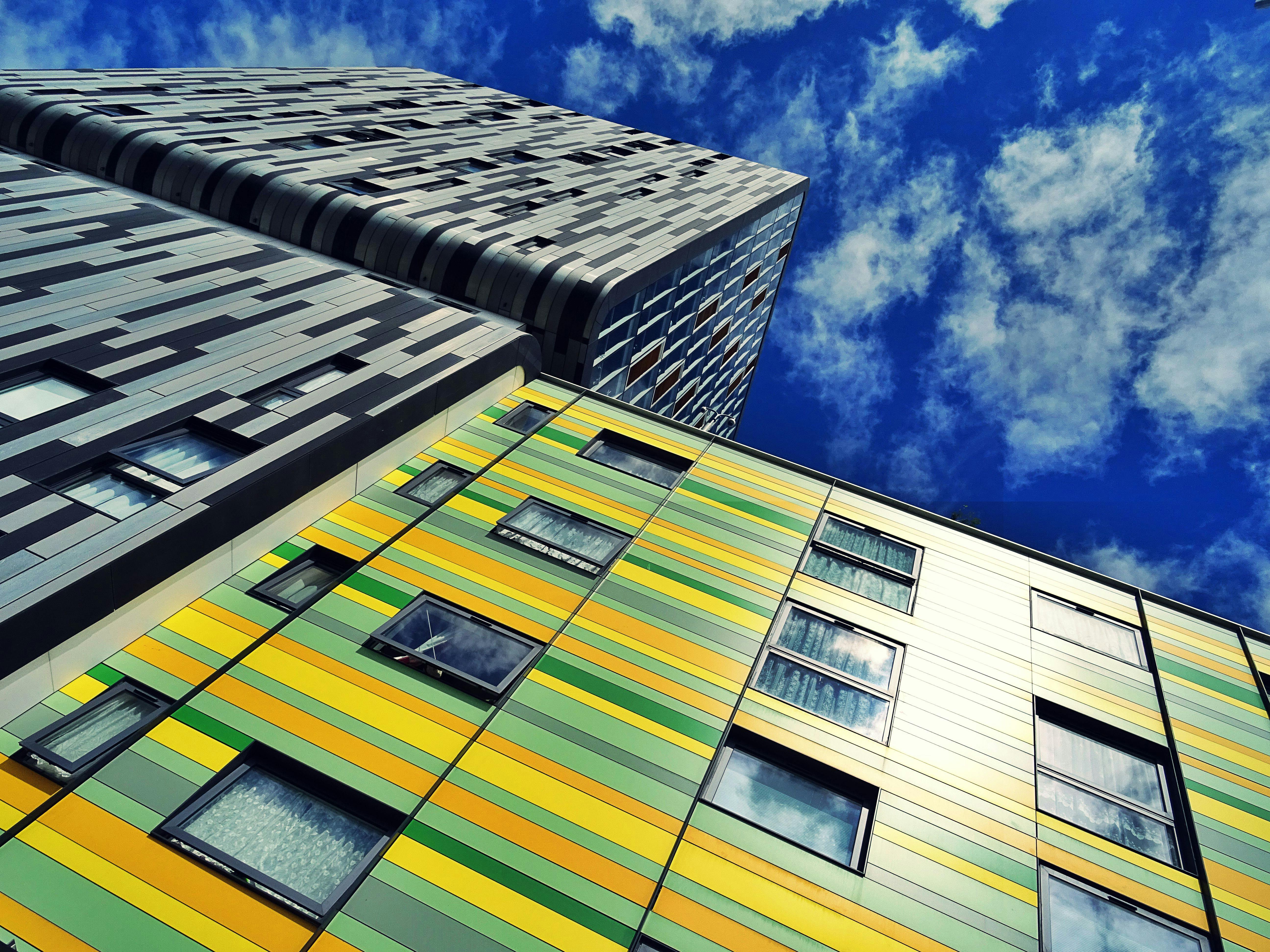 低角度拍摄的现代摩天大楼，在蓝天的映衬下色彩缤纷