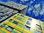 低角度拍摄的现代摩天大楼，在蓝天的映衬下色彩缤纷