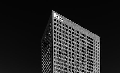 Black and white corner of contemporary multi storey office building on black background