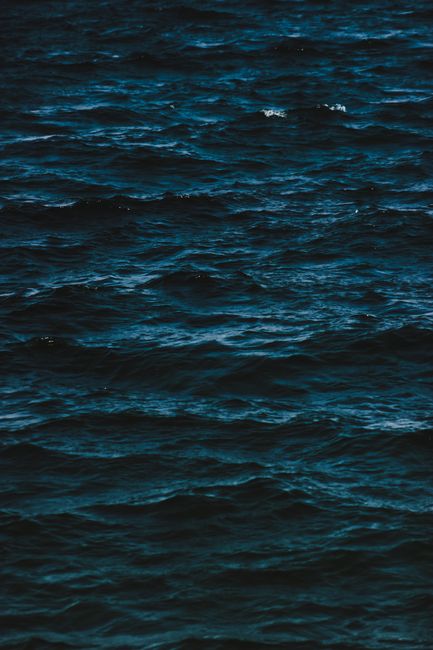 Abstract background of dark rippling surface of endless sea in rich ultramarine color