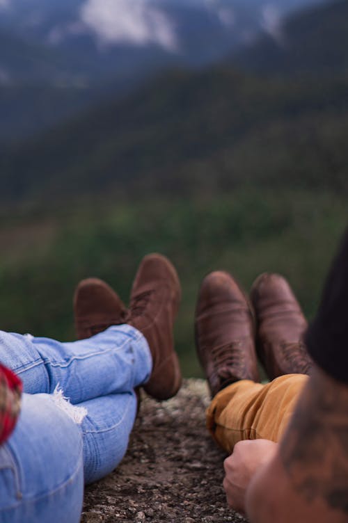 Faceless hikers resting on mountain in valley