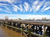 木制码头延伸向城市天际线，蓝天映衬下云层格外引人注目